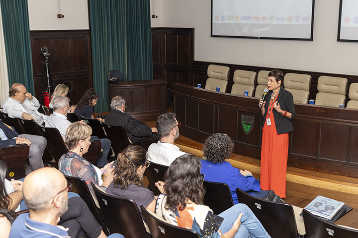 A reitora, Raiane Assumpção, realizando a apresentação das ações da gestão