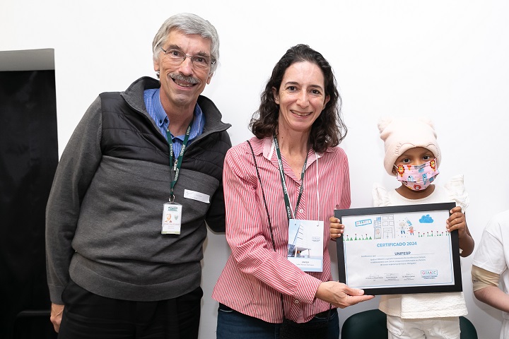 João Aléssio Perfeito, docente da EPM, e Isabel Quadros, recebendo a certificação por parte da organização da corrida